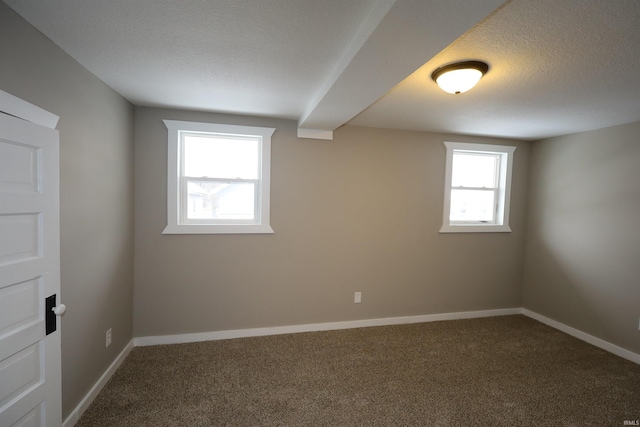 unfurnished room featuring a textured ceiling and carpet flooring