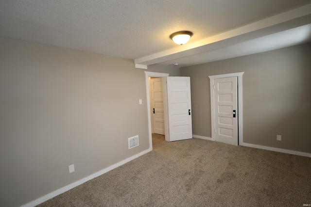 unfurnished room featuring carpet floors and a textured ceiling