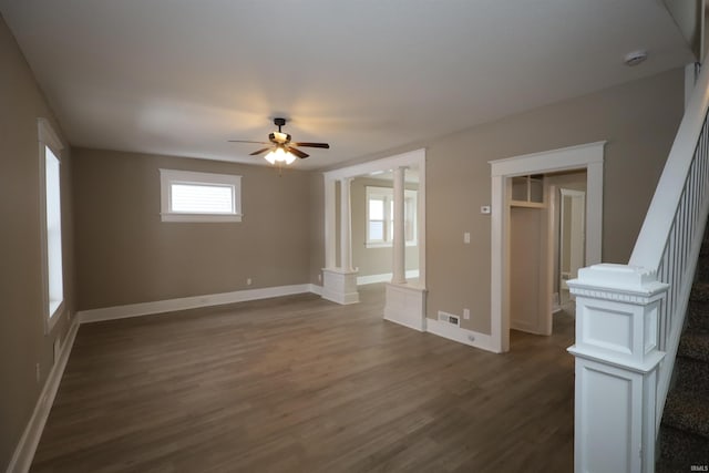 empty room featuring dark hardwood / wood-style flooring, decorative columns, and ceiling fan