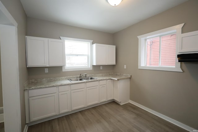 kitchen with white cabinetry, sink, and light hardwood / wood-style floors