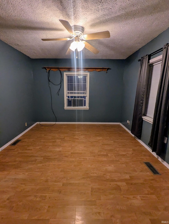 unfurnished room with ceiling fan, light hardwood / wood-style flooring, and a textured ceiling