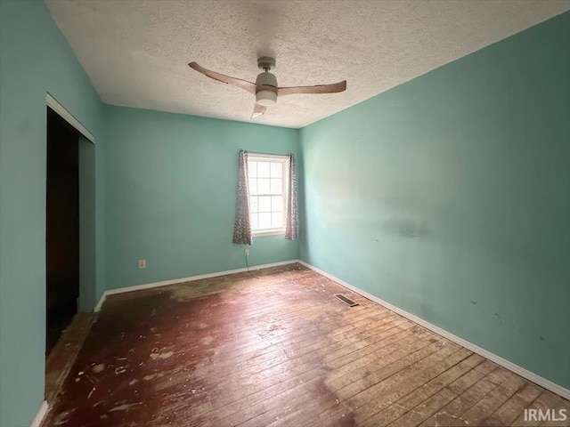 unfurnished room featuring a textured ceiling, ceiling fan, and dark wood-type flooring