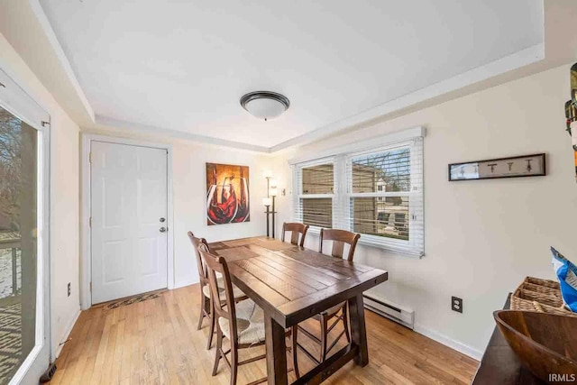 dining area with a baseboard radiator and light hardwood / wood-style floors