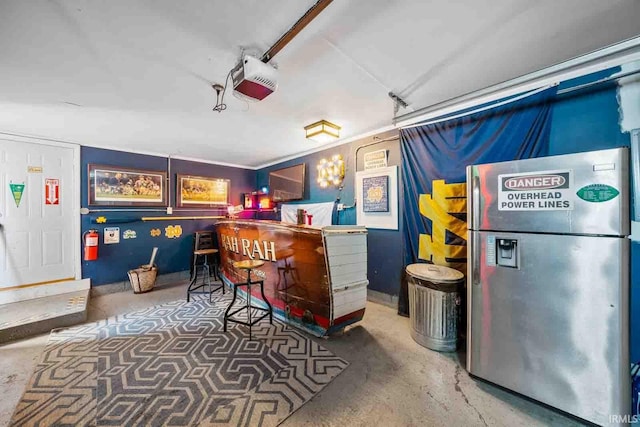 interior space featuring stainless steel fridge and concrete floors