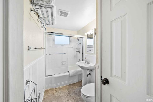 bathroom featuring shower / bath combination with glass door and toilet