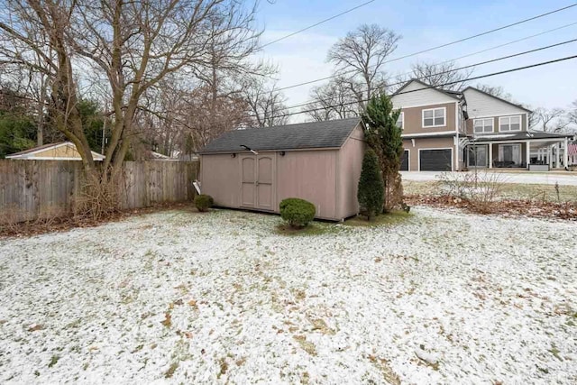 yard layered in snow with a storage shed