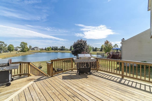 wooden terrace with area for grilling and a water view