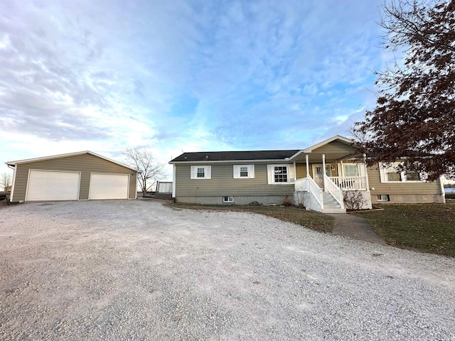 view of front of property with a porch, a garage, and an outbuilding