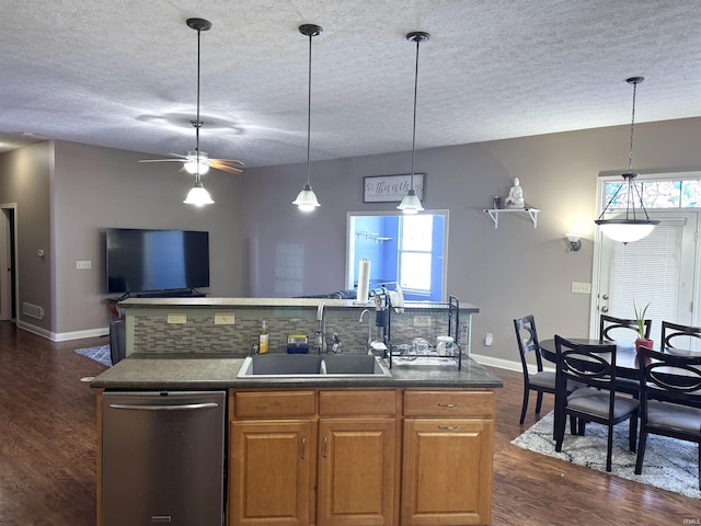 kitchen with dishwasher, sink, a kitchen island with sink, pendant lighting, and decorative backsplash