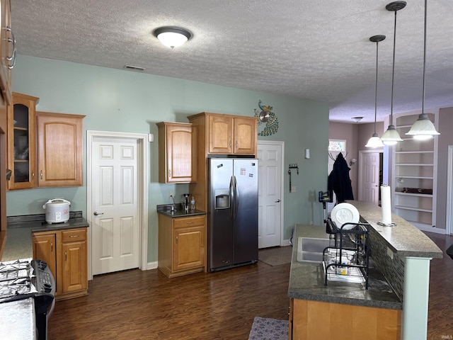 kitchen with dark hardwood / wood-style flooring, range, a textured ceiling, decorative light fixtures, and stainless steel fridge with ice dispenser