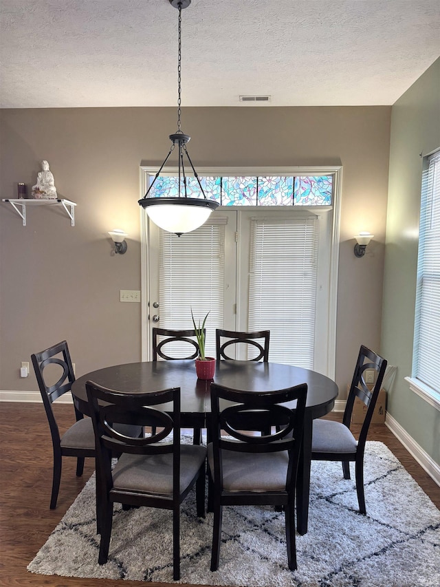 dining area featuring a textured ceiling and dark wood-type flooring