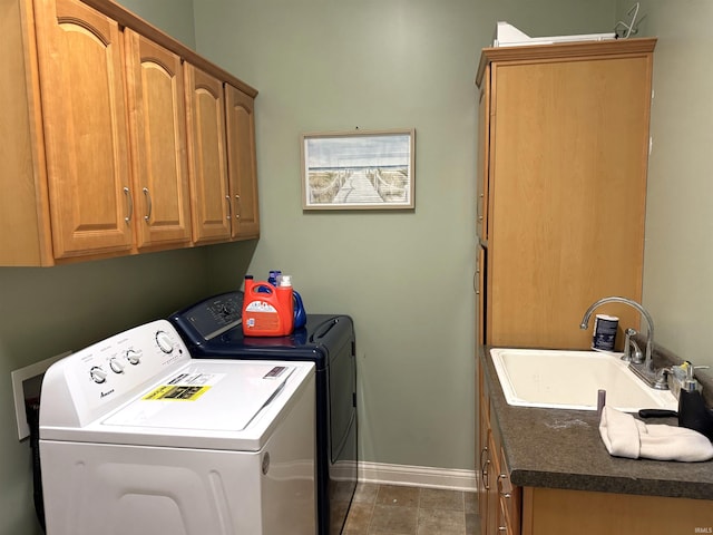 laundry area with separate washer and dryer, sink, and cabinets