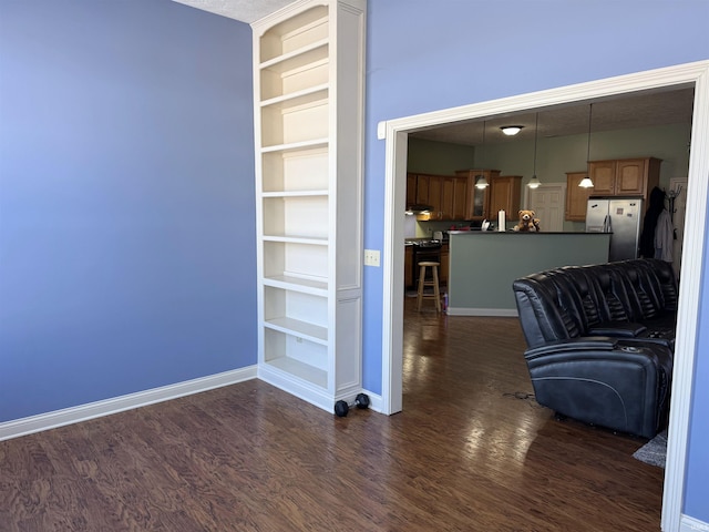 unfurnished living room featuring dark hardwood / wood-style flooring and built in features