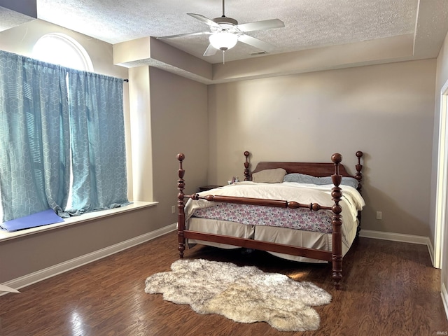 bedroom featuring a textured ceiling, dark hardwood / wood-style floors, and ceiling fan