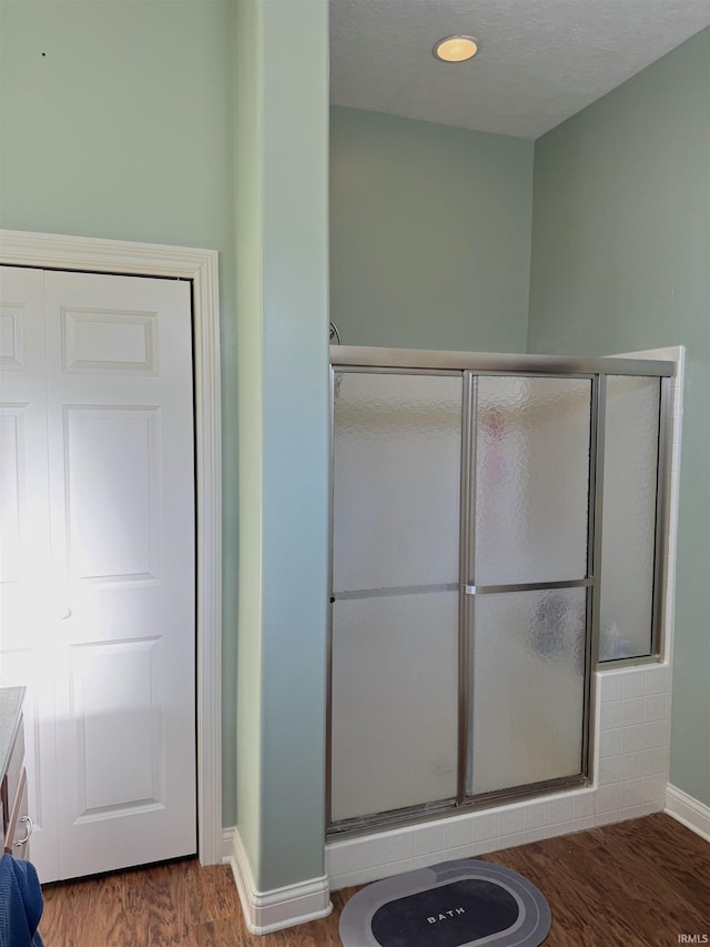 bathroom featuring hardwood / wood-style floors, vanity, and an enclosed shower