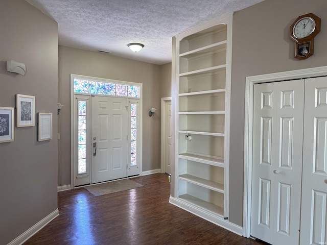 foyer with dark hardwood / wood-style floors and a textured ceiling