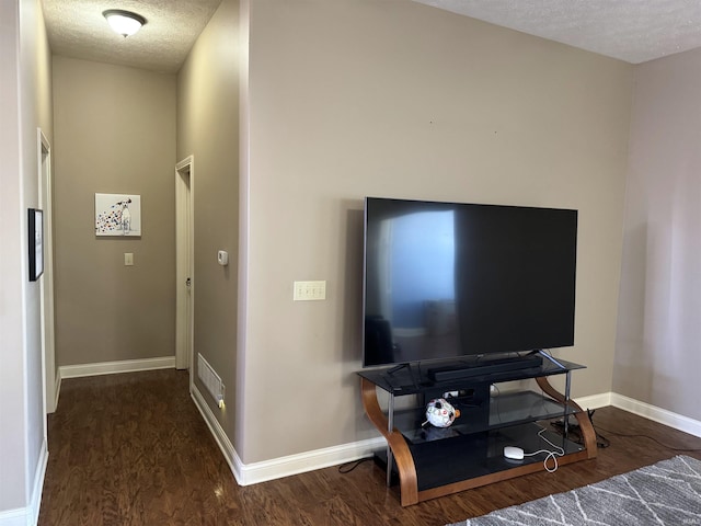 living room with a textured ceiling and dark wood-type flooring