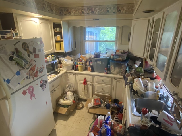 kitchen featuring sink, white cabinets, light tile patterned flooring, and white refrigerator