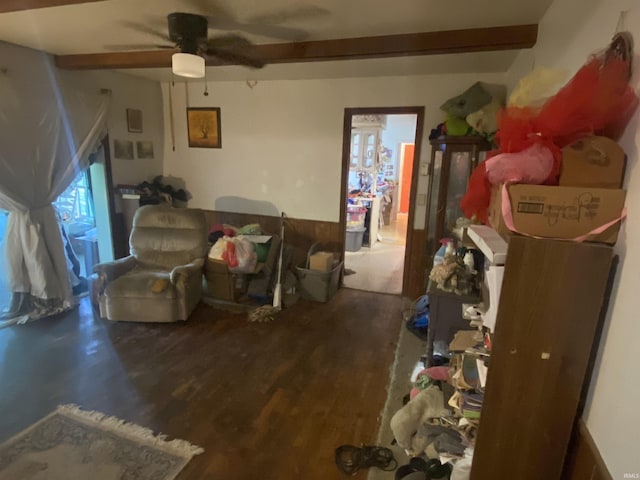 living room with a wealth of natural light, ceiling fan, beamed ceiling, and hardwood / wood-style flooring