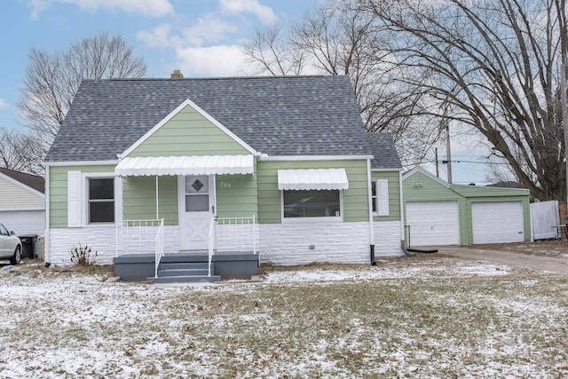 bungalow featuring a garage and an outbuilding