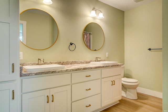 bathroom with vanity, hardwood / wood-style flooring, and toilet