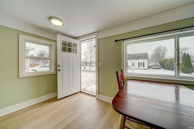 entryway with a textured ceiling and light wood-type flooring