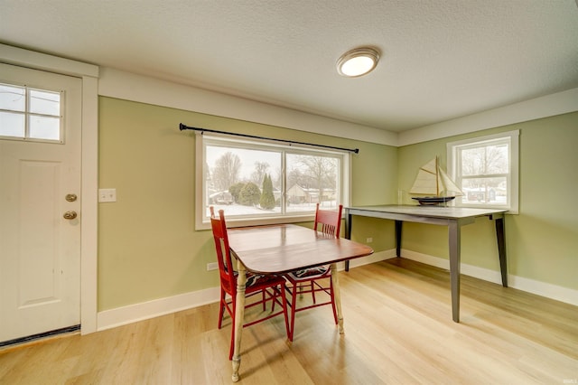 dining space with light hardwood / wood-style flooring and a textured ceiling