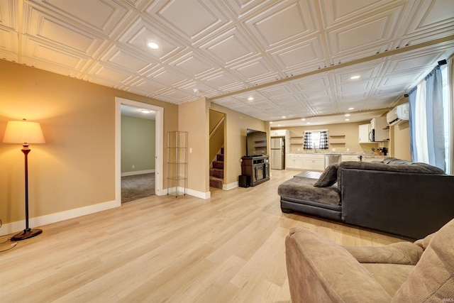 living room with a wall mounted AC and light wood-type flooring