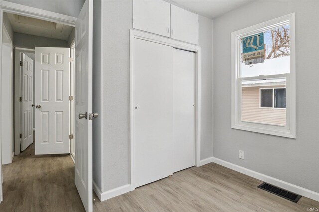 unfurnished bedroom with light hardwood / wood-style floors and a closet