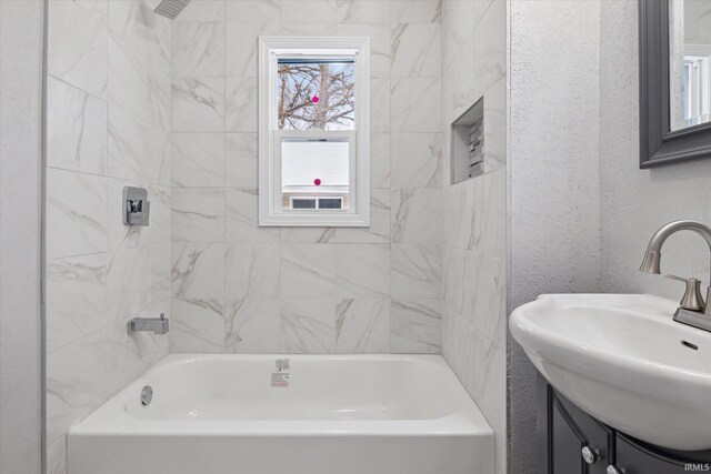 bathroom with vanity and tiled shower / bath