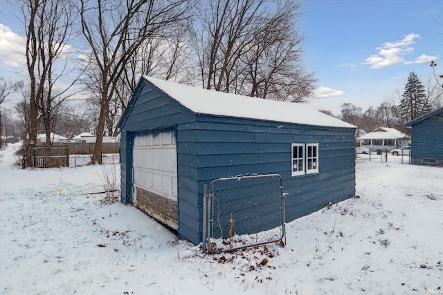 snow covered structure featuring a garage