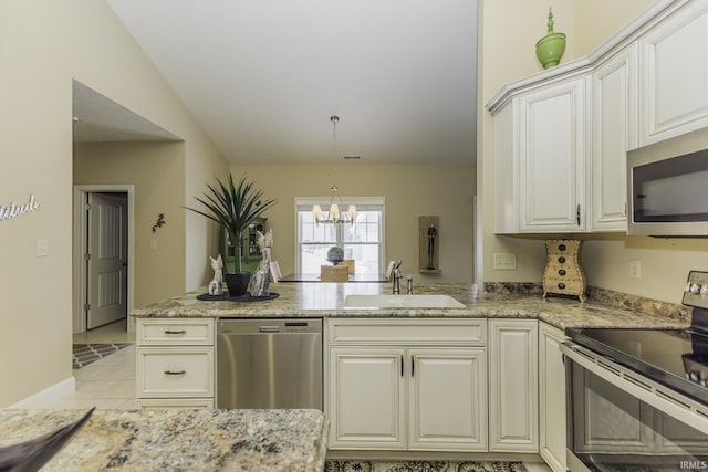 kitchen with sink, an inviting chandelier, vaulted ceiling, light tile patterned flooring, and appliances with stainless steel finishes