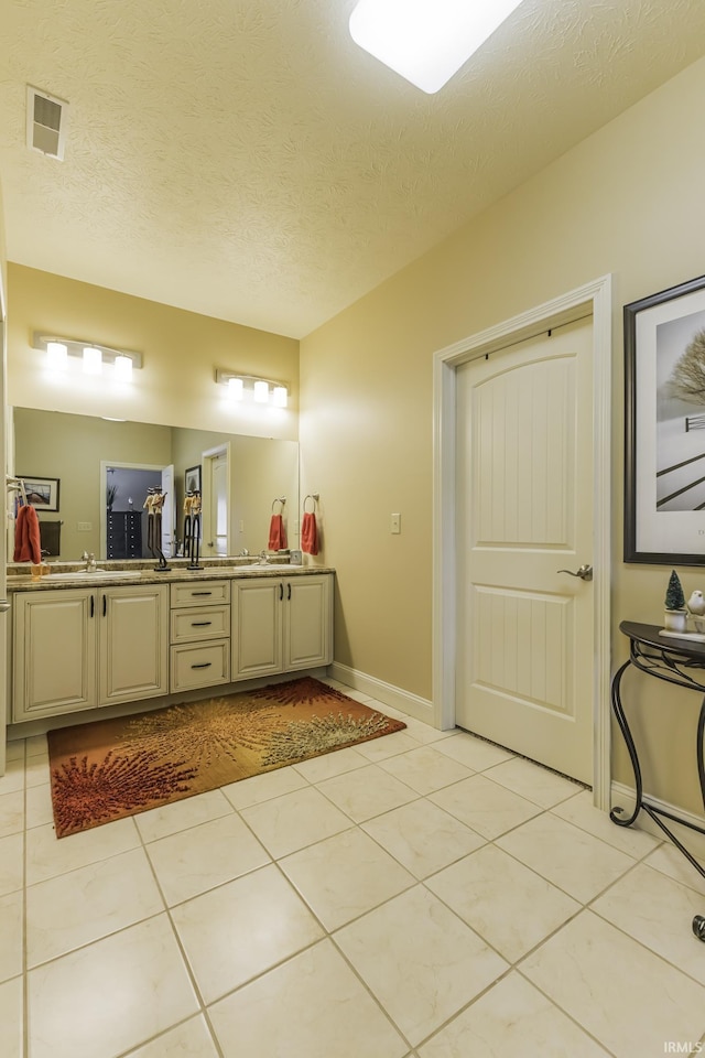 bathroom with tile patterned floors, vanity, and a textured ceiling