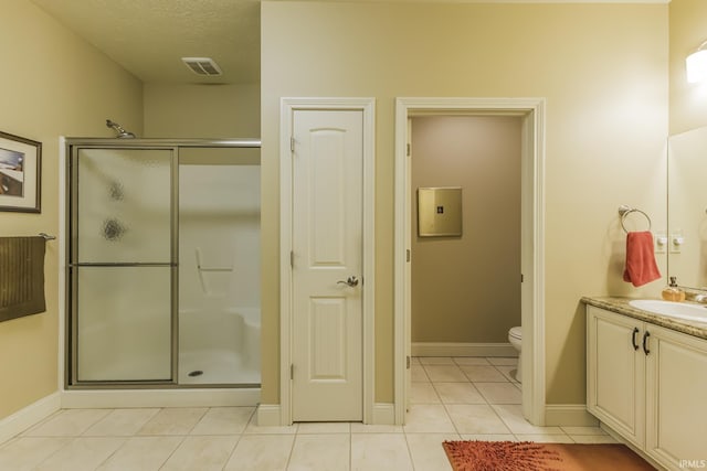 bathroom with tile patterned floors, an enclosed shower, vanity, a textured ceiling, and toilet