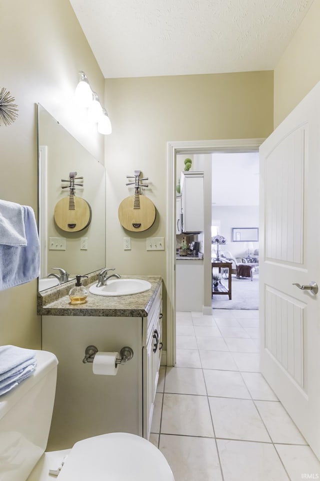 bathroom featuring tile patterned floors, vanity, toilet, and a textured ceiling