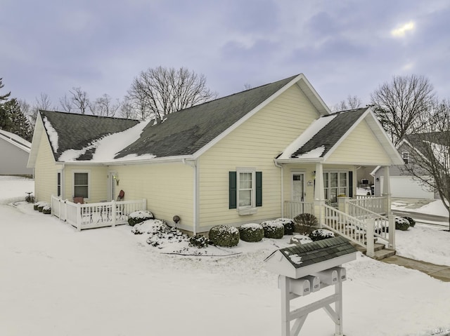 snow covered property with covered porch