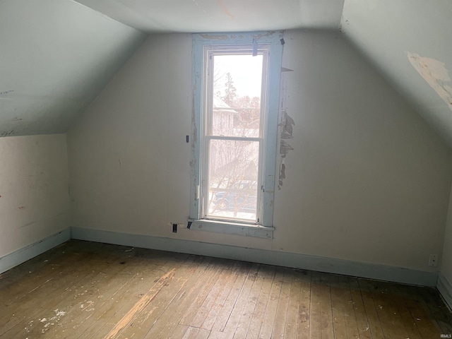 bonus room with hardwood / wood-style flooring and vaulted ceiling