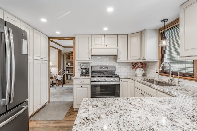 kitchen featuring sink, stainless steel appliances, pendant lighting, white cabinets, and custom exhaust hood