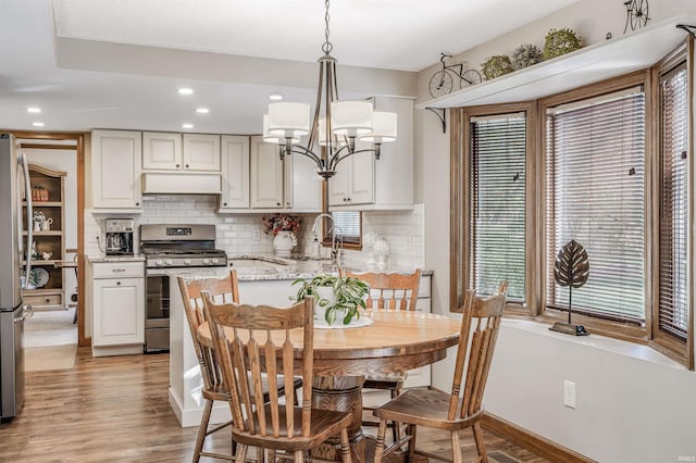 dining room featuring light hardwood / wood-style floors, a notable chandelier, and sink