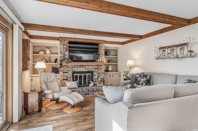 living room with a fireplace, built in features, and hardwood / wood-style floors