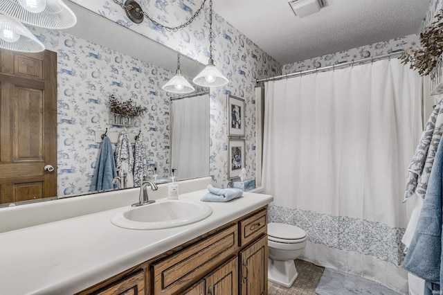 bathroom with vanity, a textured ceiling, and toilet