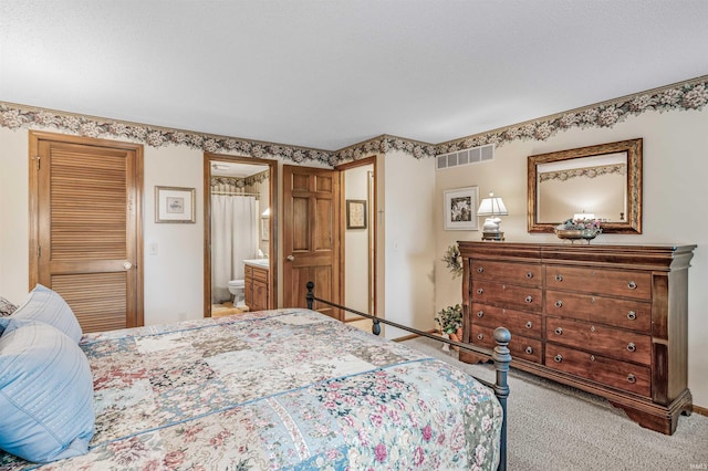 bedroom with carpet floors and ensuite bath