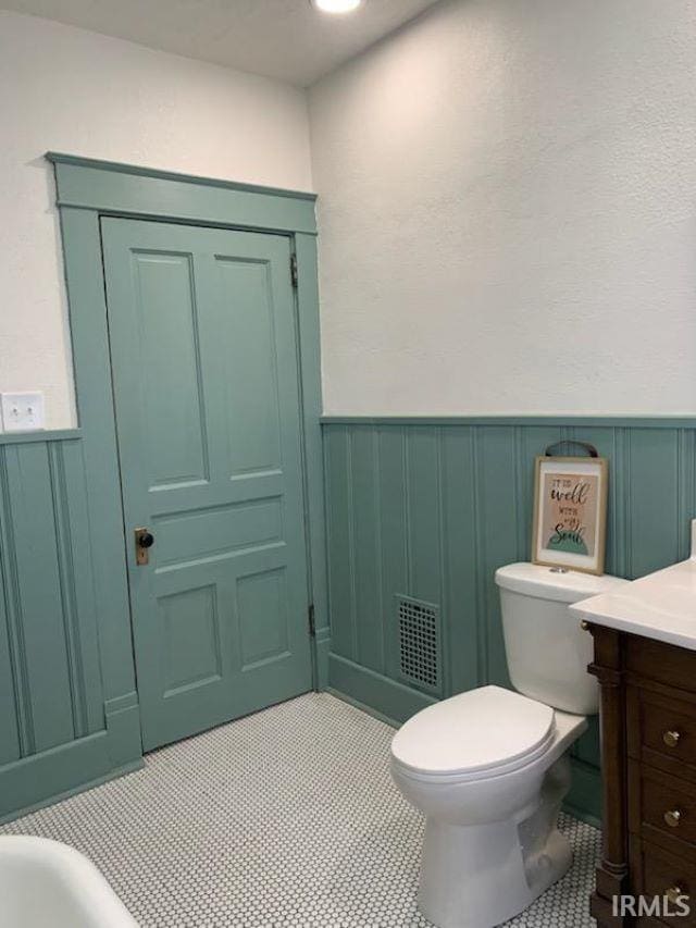 bathroom with toilet, vanity, and tile patterned floors