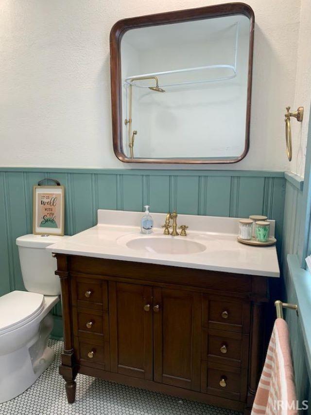 bathroom featuring tile patterned flooring, vanity, and toilet