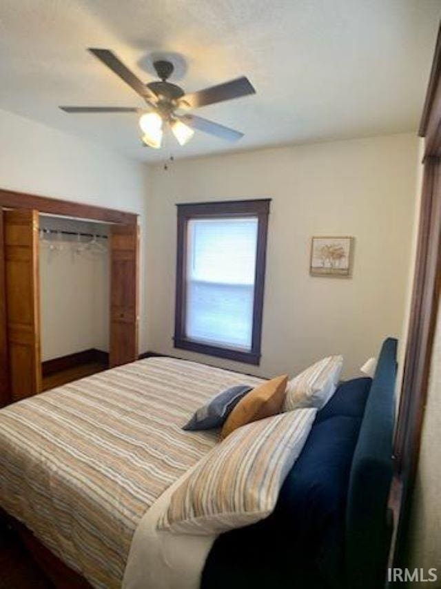 bedroom with ceiling fan and a closet