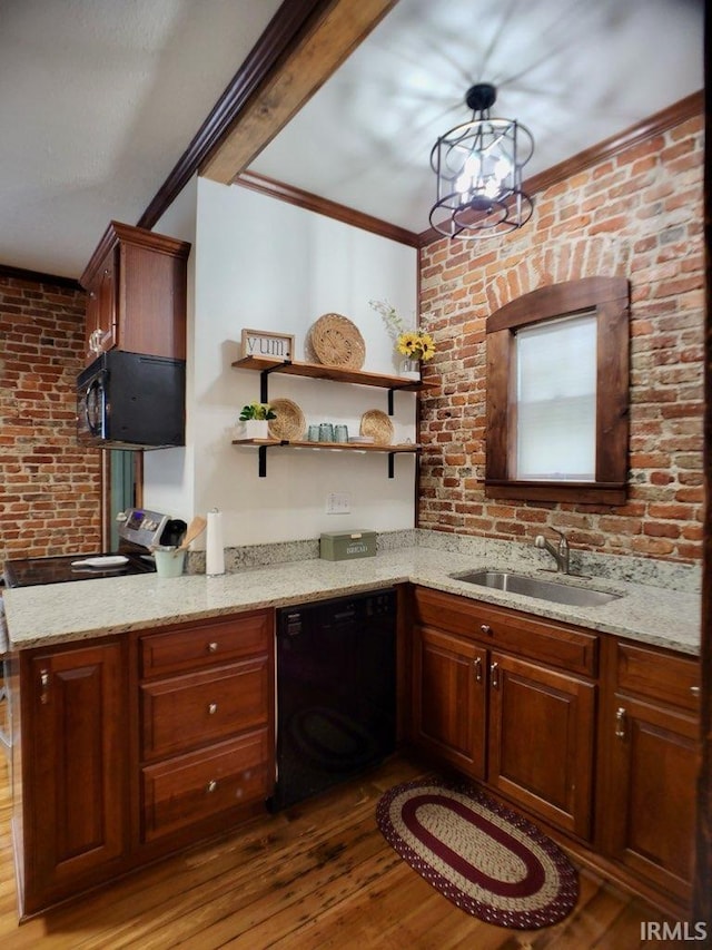 kitchen with black appliances, wood-type flooring, sink, light stone countertops, and kitchen peninsula