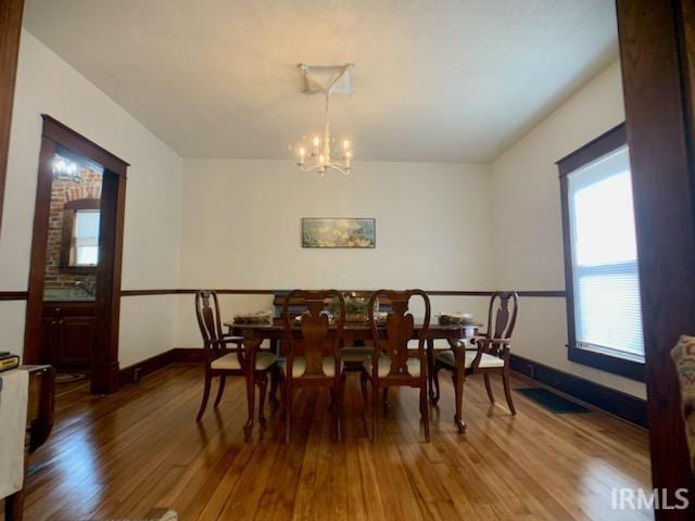 dining room featuring hardwood / wood-style floors and an inviting chandelier