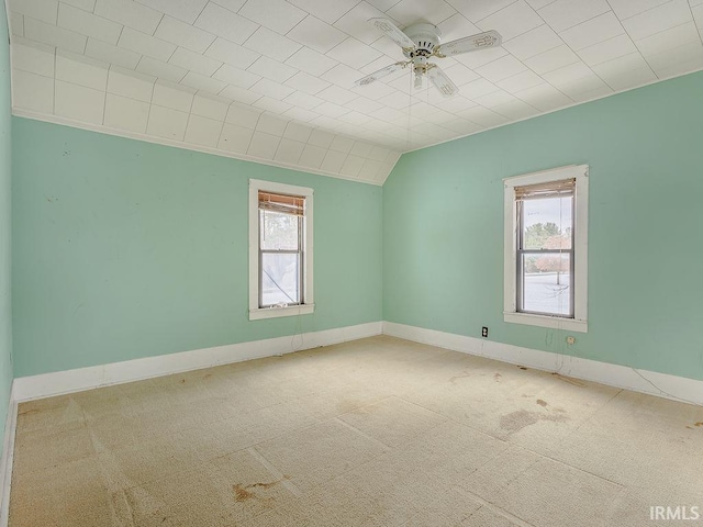 carpeted spare room with vaulted ceiling and ceiling fan