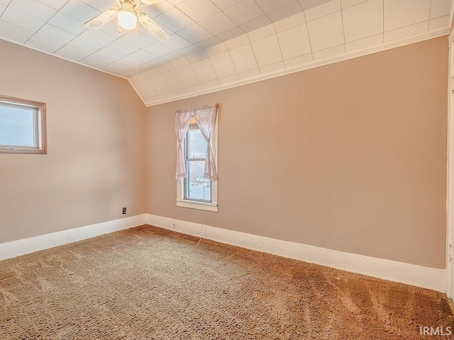 unfurnished room with carpet, vaulted ceiling, ceiling fan, and ornamental molding