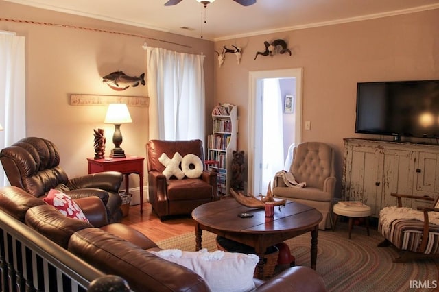 sitting room featuring hardwood / wood-style floors, ceiling fan, and crown molding